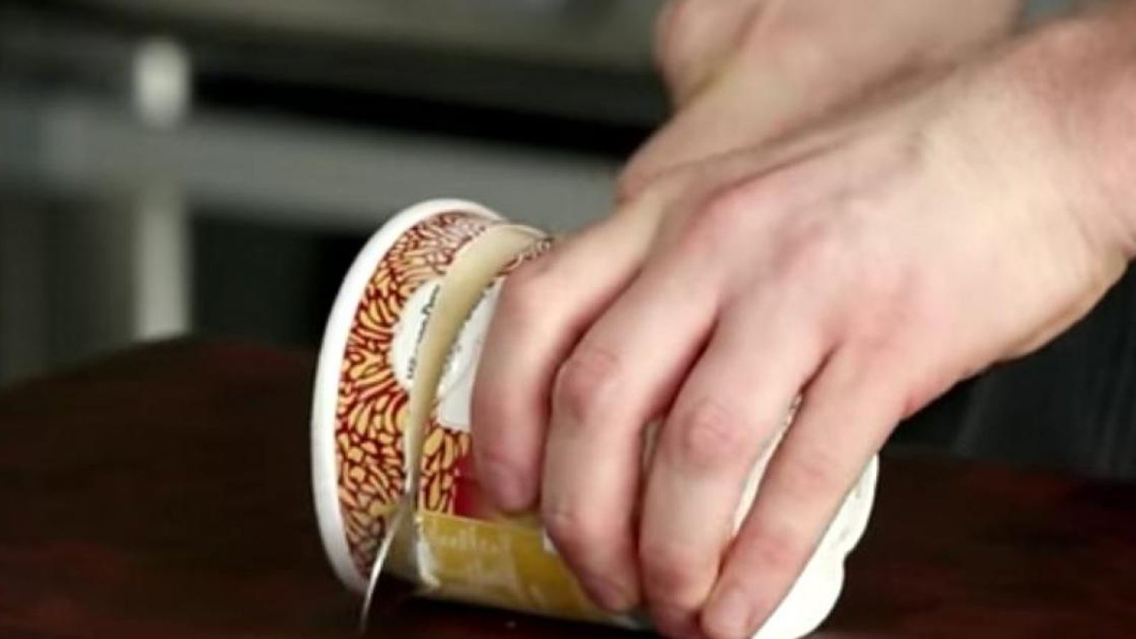 Avec un grand couteau, il coupe son pot de crème glacée en plusieurs tranches. Son idée est fantastique!