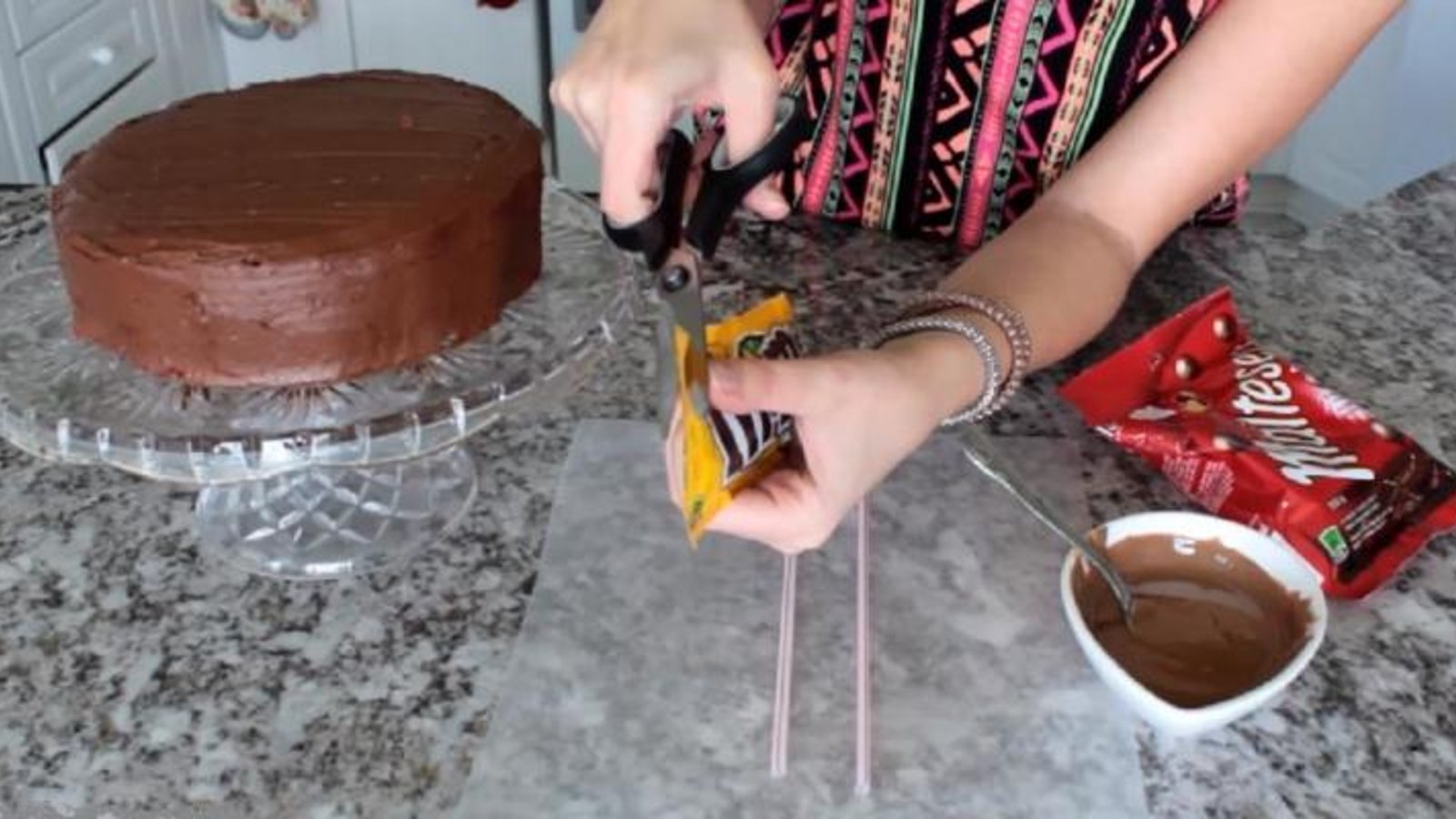 Elle ouvre un sachet de bonbons pour décorer son gâteau! Mais gardez bien les yeux sur le gâteau! 