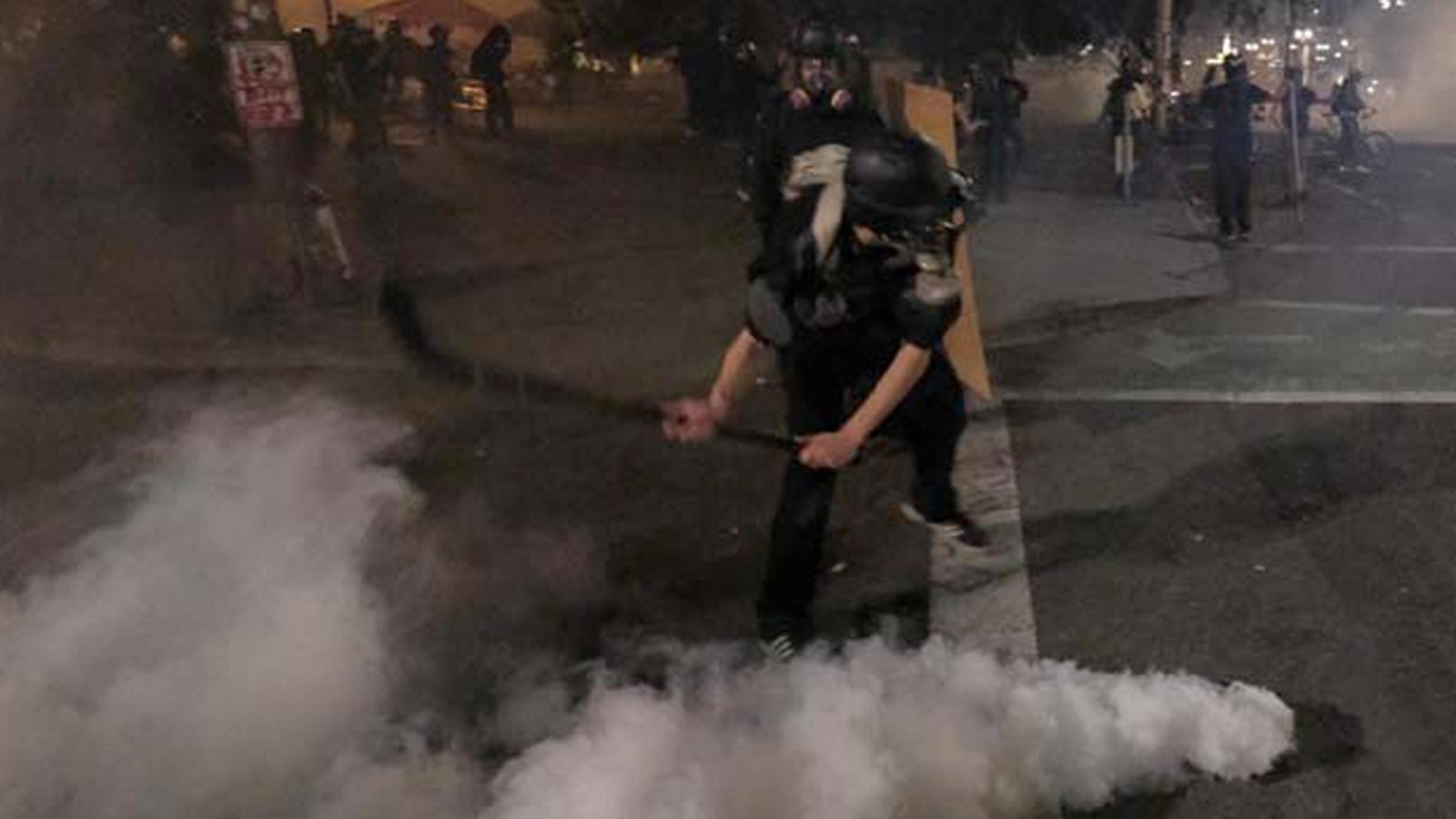 Protester uses hockey stick to slapshot tear gas canister at Portland police