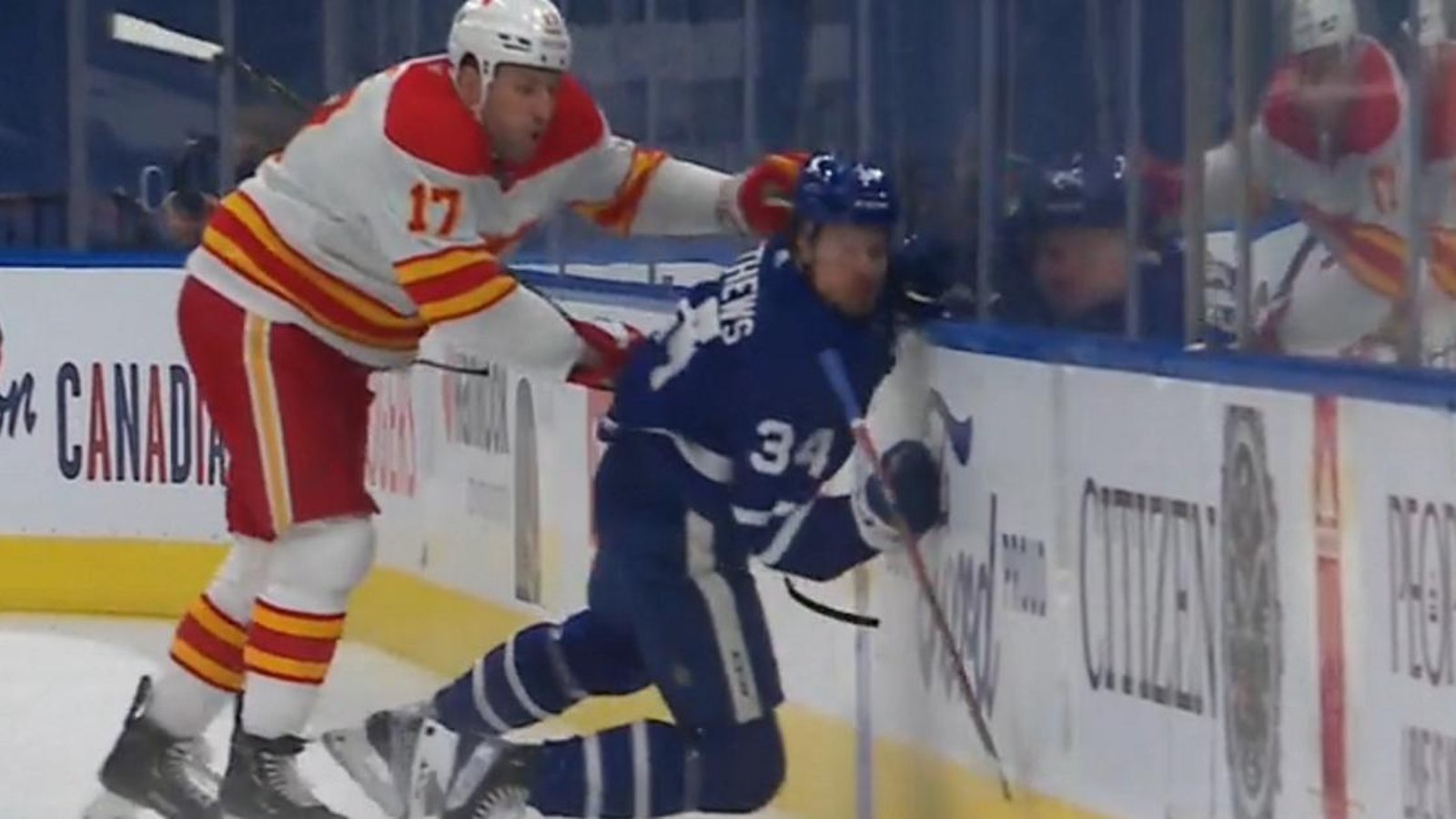 Milan Lucic sends Auston Matthews into the boards with a hit from behind.