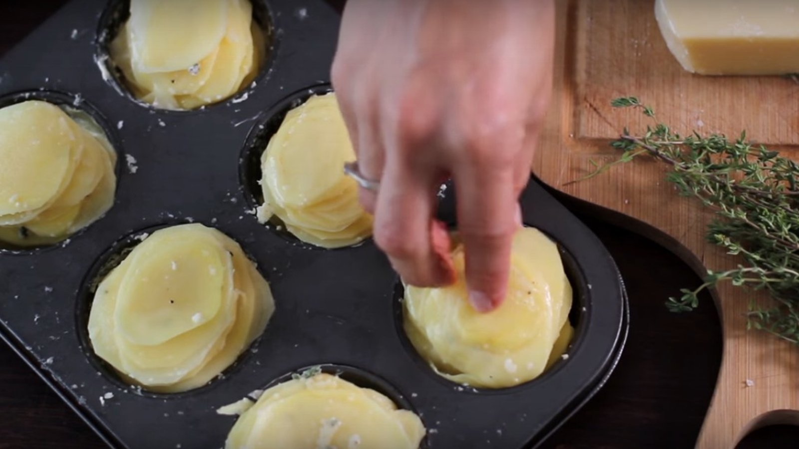 Elle empile des tranches de pommes de terre dans un moule à muffins afin de créer un plat d'accompagnement vraiment divin