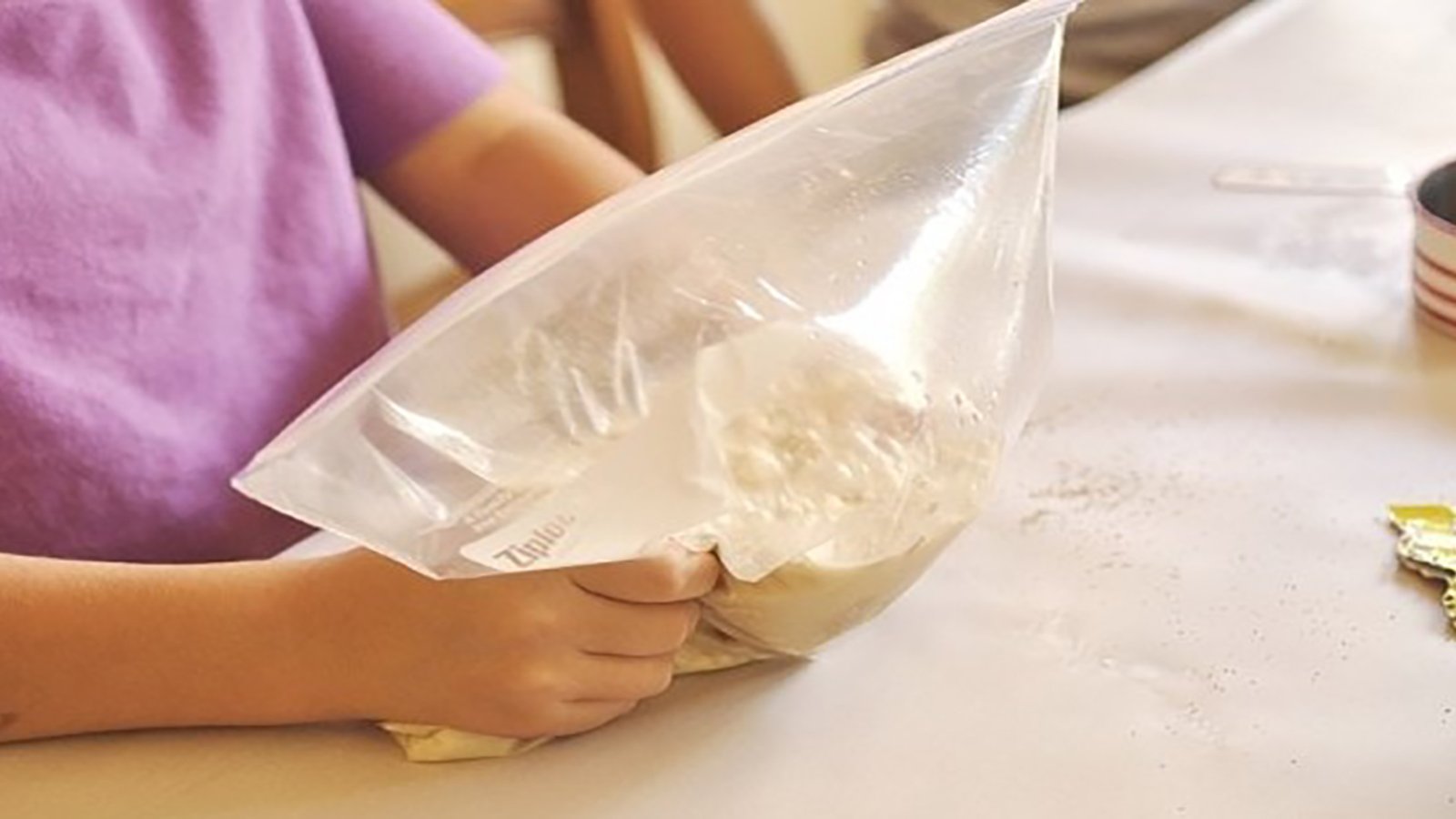 Elle met de la farine et de la levure dans un sac à glissière afin de créer le meilleur pain qui soit